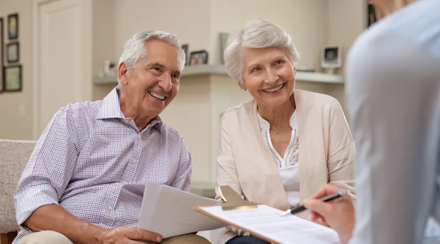 Senior couple reviewing legal documents with an Elder Law Lawyer, ensuring their estate and long-term care planning is secure.