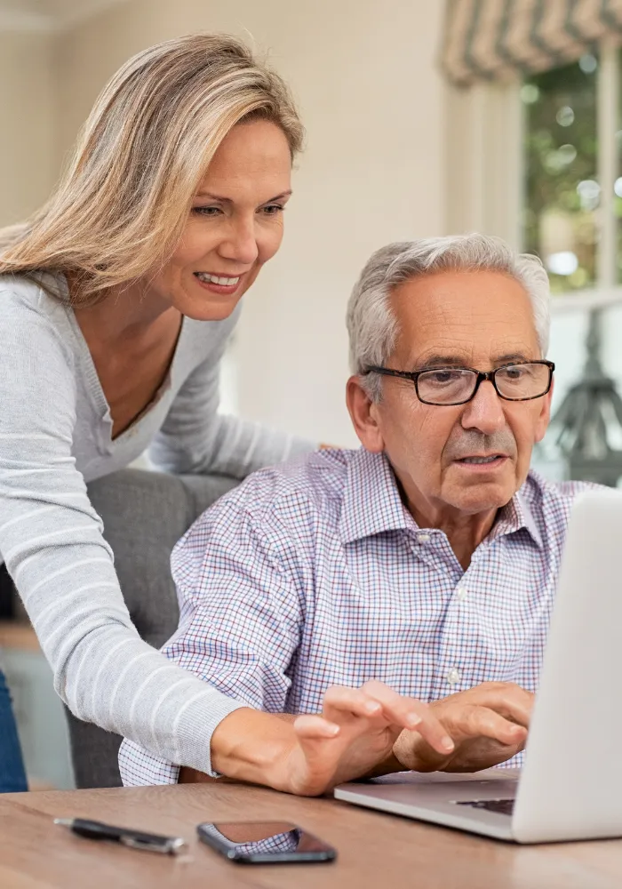 Elderly father and adult daughter reviewing home deed and estate paperwork together in Florida kitchen