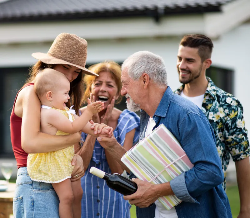 WP Family members smiling and supporting one another while discussing legal care planning for aging parents Amy Dow Elder Law Attorney ( 800 x 700px) Multigenerational family smiling together outside, symbolizing elder law planning and connection