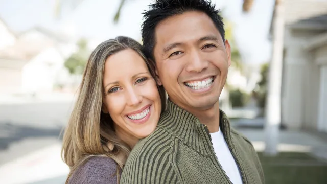 Happy couple standing in front of their Florida home after completing a Lady Bird Deed