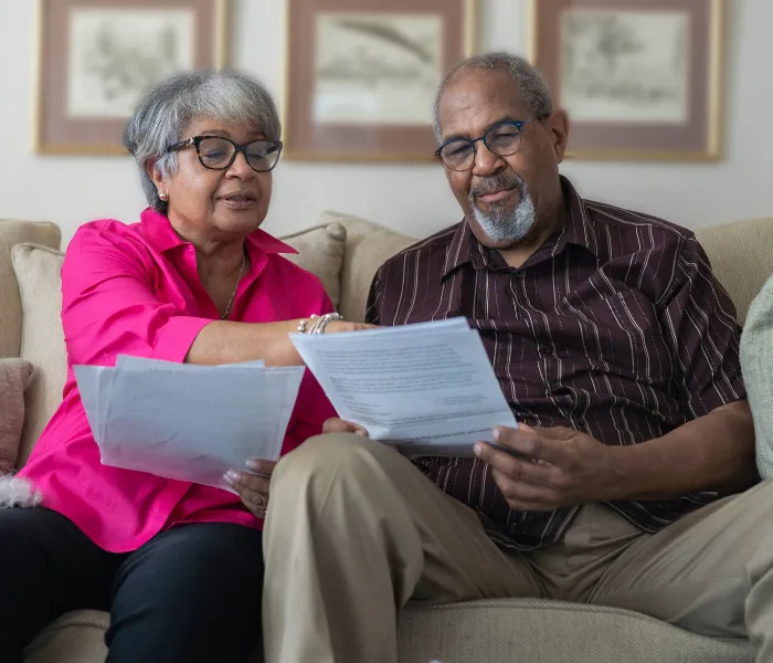 Senior couple reviewing Medicaid paperwork at home, reflecting the emotional weight of planning long-term care