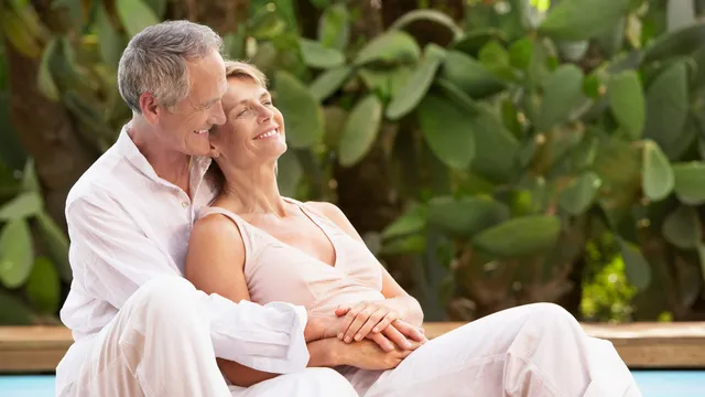Smiling couple relaxing outdoors, feeling peaceful after completing their health care directive and legal planning
