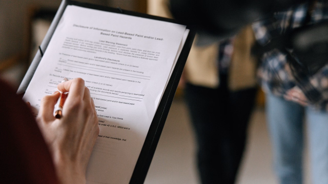 Person reviewing and signing Florida trust and estate planning paperwork during a legal consultation for an older parent living in Florida